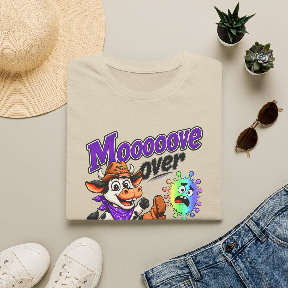 Folded tan Moooove Over Cancer T-shirt showing the Western artwork