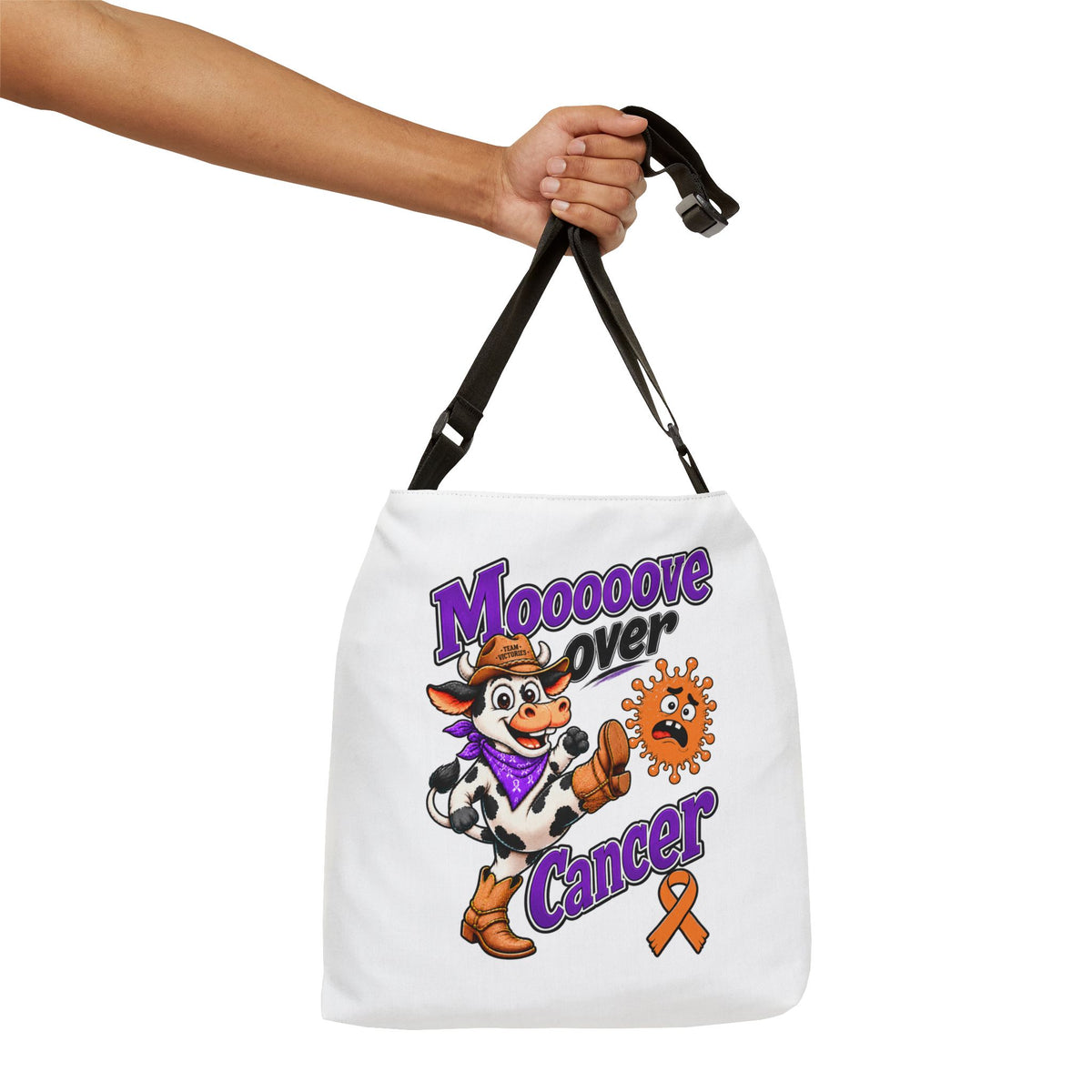 Hand holding the adjustable strap of a Moooove Over Cancer tote