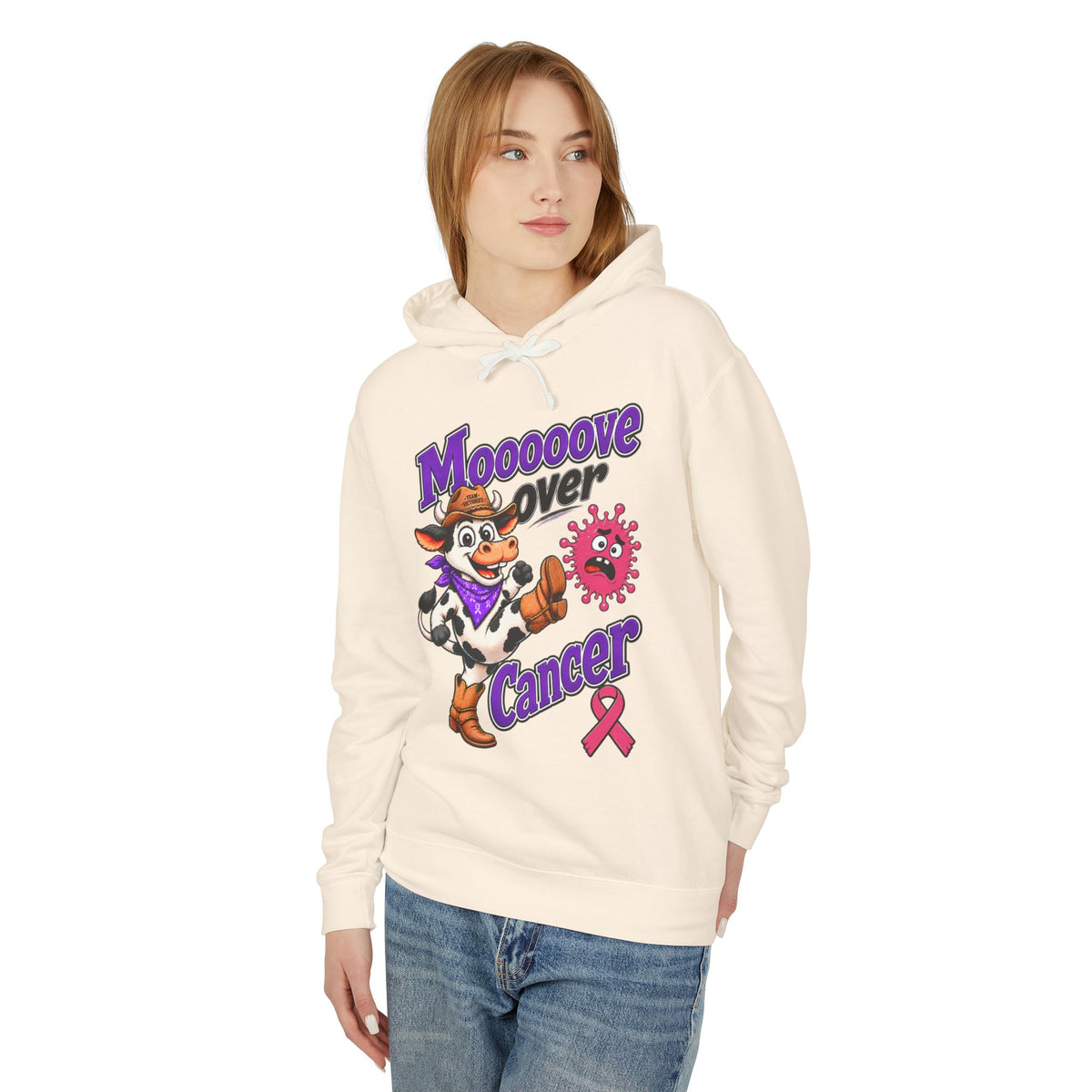 Woman modeling a cream Moooove Over Cancer hoodie with Breast Cancer awareness ribbon artwork