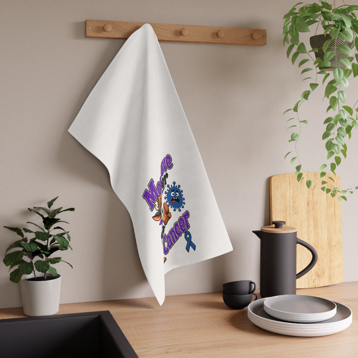 Moooove Over Cancer tea towel hanging beside dishes and kitchen accessories
