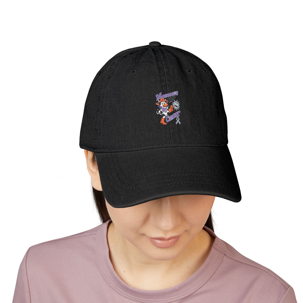 Person wearing the black Moooove Over Cancer embroidered denim hat