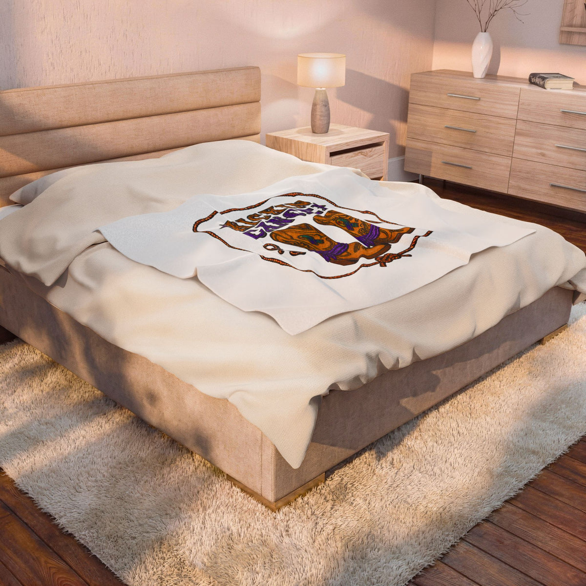 White Kickin' Cancer blanket draped across a bed with western awareness artwork